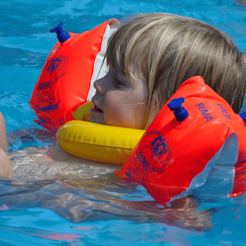 Kind nutzt eine Schwimmhilfe im Schwimmkurs
