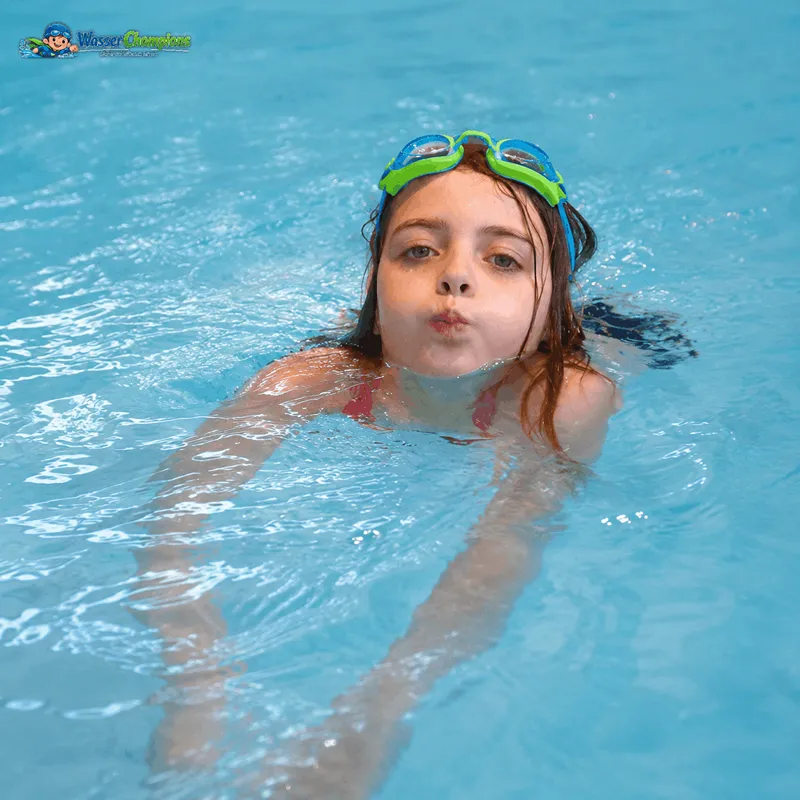 Kind nach dem Seepferdchen beim Schwimmen im Hallenbad