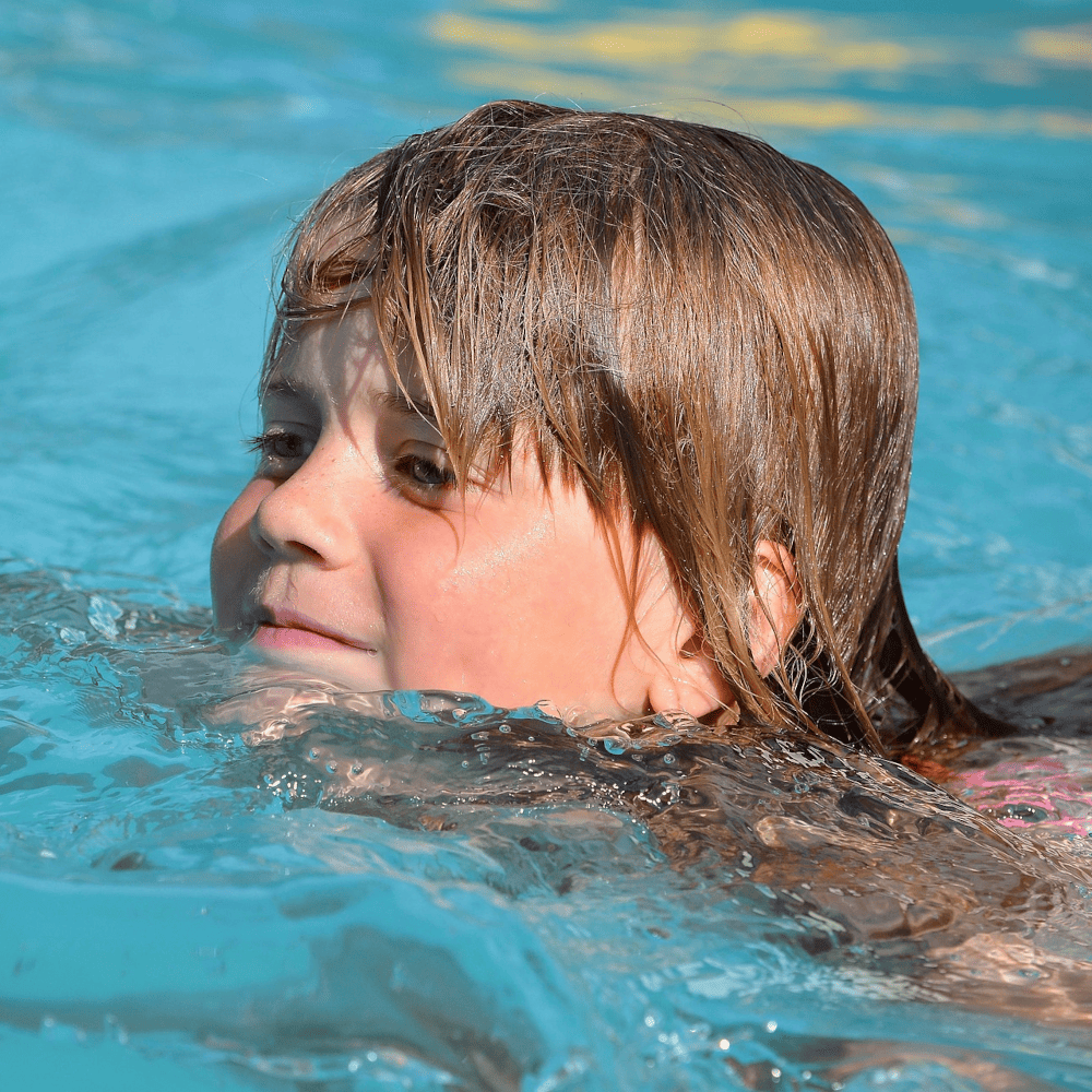 Kind übt für das Seepferdchen im Schwimmkurs