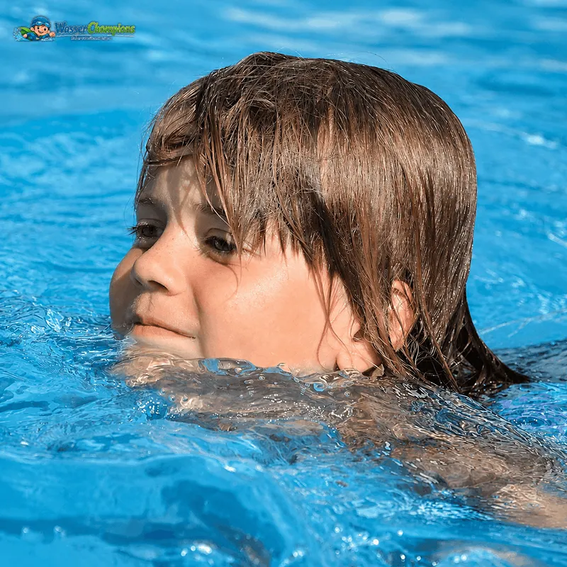 Kind im Schwimmkurs lernt Schritt für Schritt schwimmen